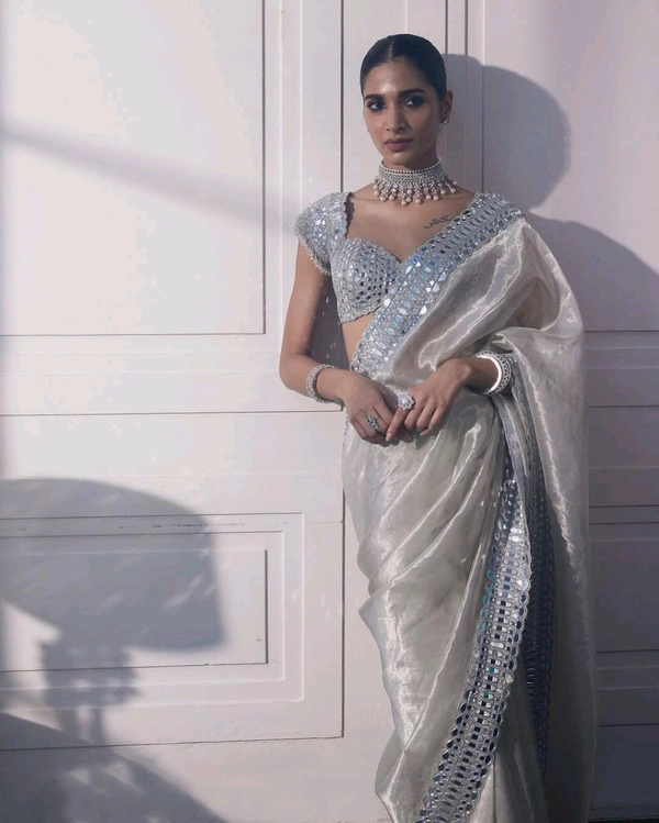 Slay in style with this one of a kind which allures your beauty and soothes your eyes . Here's yet another one of our saree collection which features Sift satin Organza saree which is embedded with real mirror work Embroidery all over the borders  Comes with a a fully embellished standard sized Stitched blouse.
