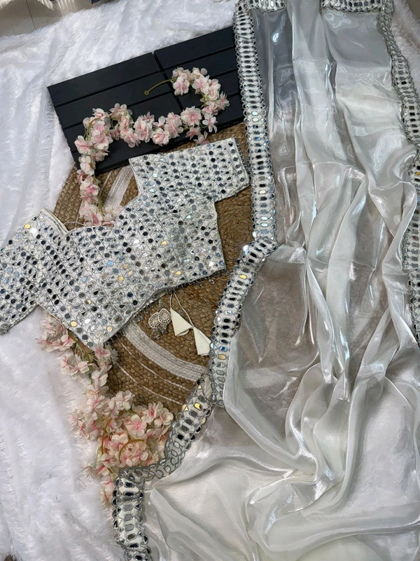 Slay in style with this one of a kind which allures your beauty and soothes your eyes . Here's yet another one of our saree collection which features Sift satin Organza saree which is embedded with real mirror work Embroidery all over the borders  Comes with a a fully embellished standard sized Stitched blouse.
